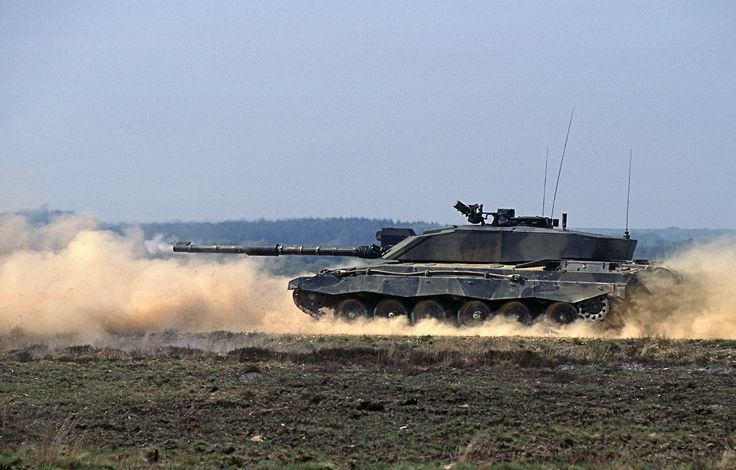 Challenger 2 Main Battle Tank (MBT) firing its main L30A1 120mm CHARM gun with High Explosive Squash Head (HESH) ammunition whilst driving at speed on Lulworth Ranges.